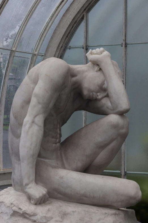 statue of a man in front of a round window