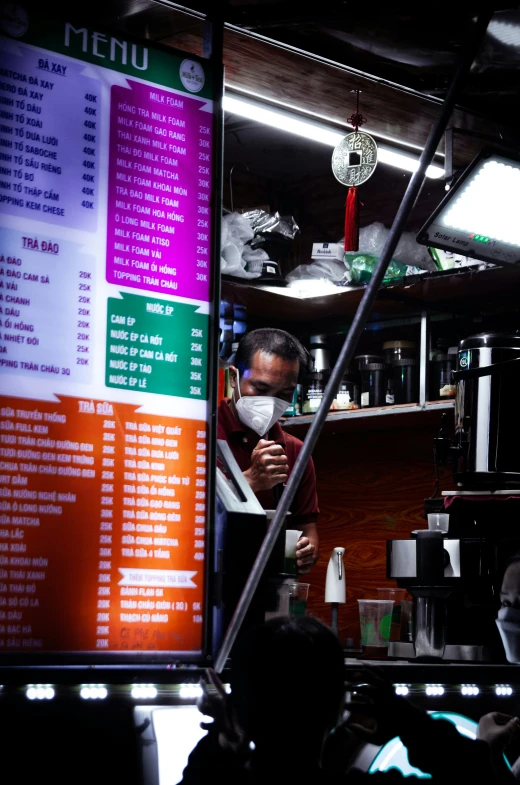 a man stands in front of the menu board