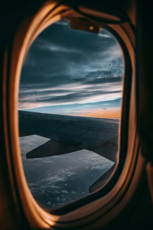 an airplane window and wing looking out the window