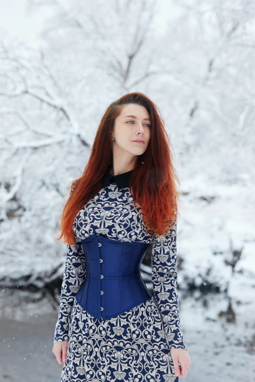 red haired woman in dress outside in the snow