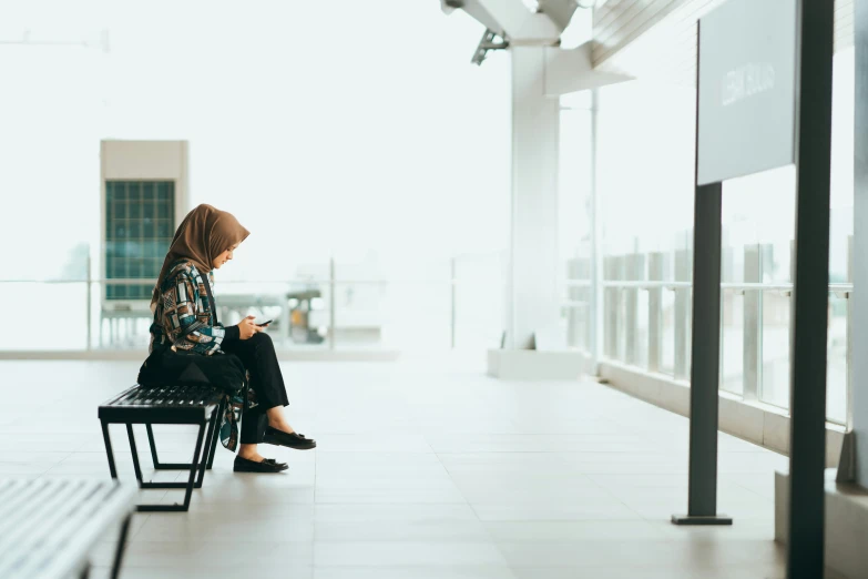 a woman sitting down looking at her cell phone