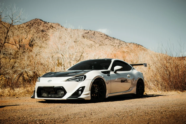 a white sports car parked in a desert