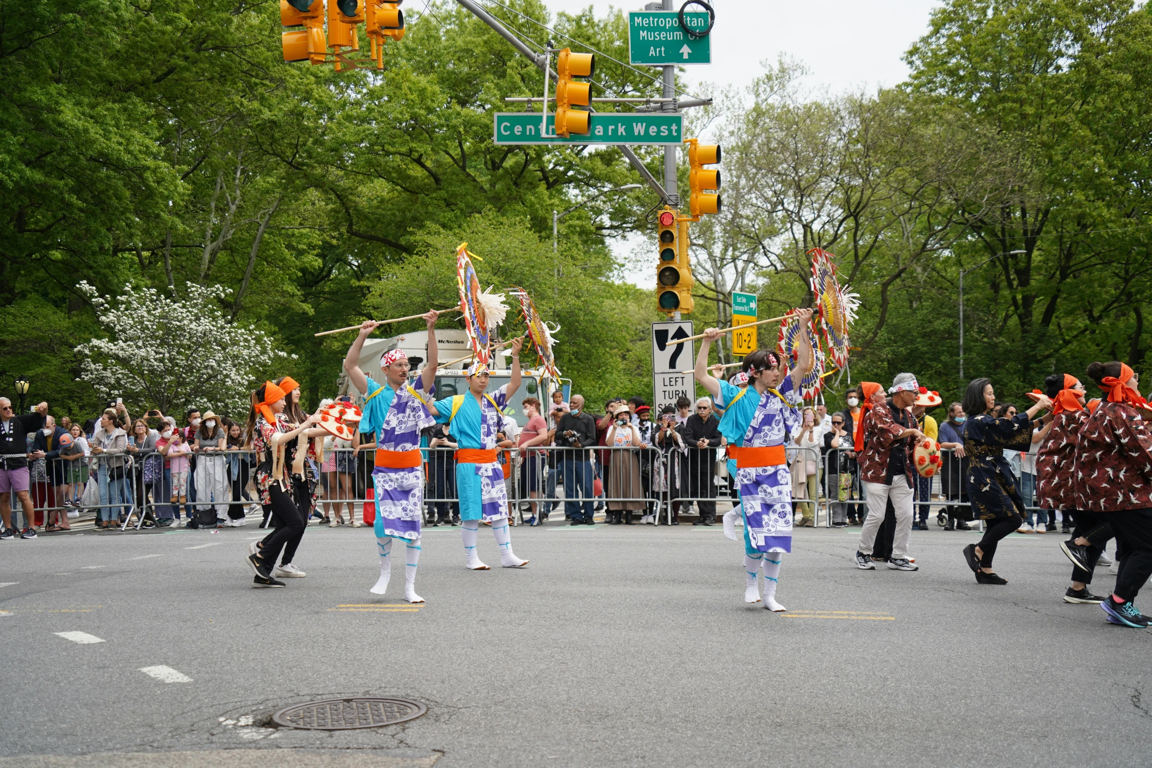 several people wearing brightly colored costumes dance on the street