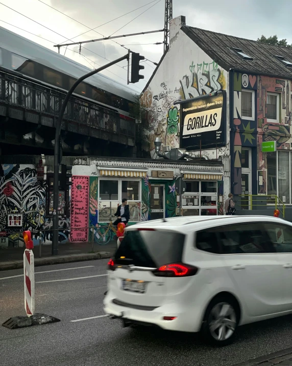 a white car is driving through the streets