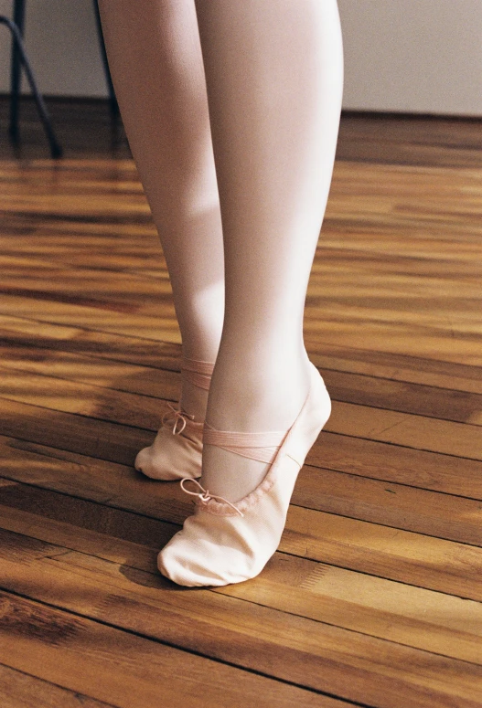 a woman with a ballerina's foot on a wood floor