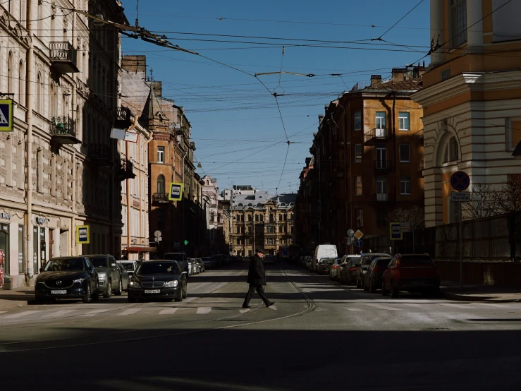 a person is crossing the street in front of several buildings