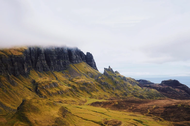 an image of mountains covered in grass and fog