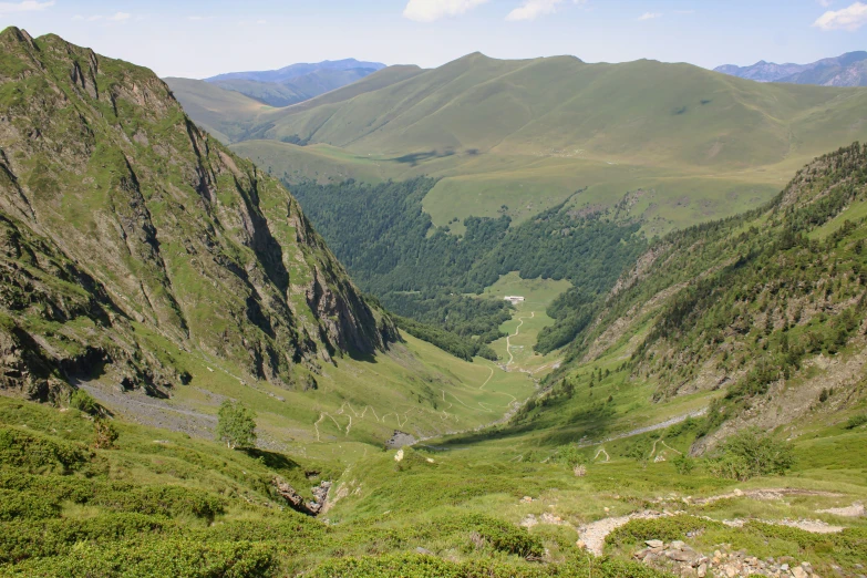 two large mountains rise in the distance and a small river flows through them