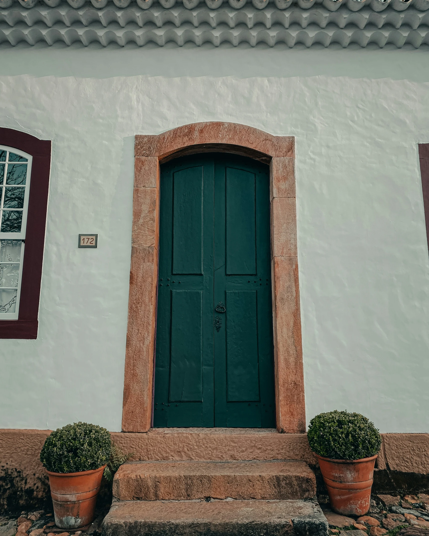 the front door of an old building with windows and planters