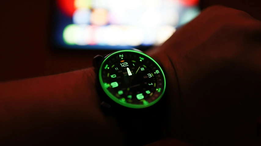 the watch has glowing lights in a dark room