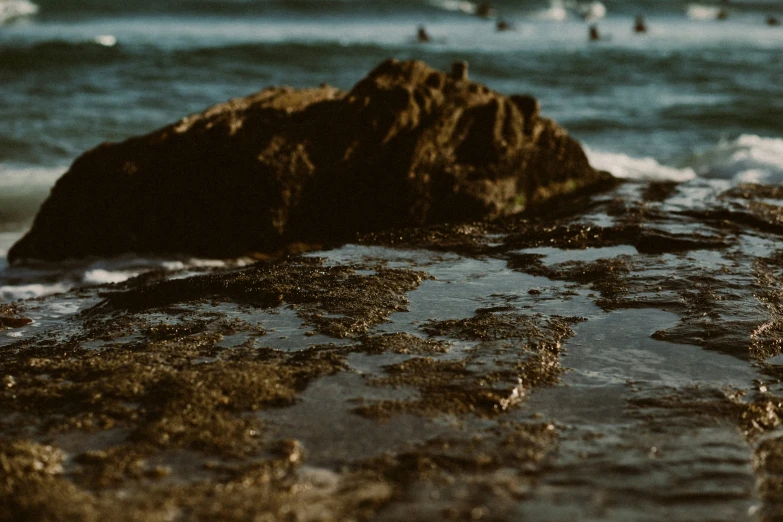 people swim on the water in the distance and a rock outcropping