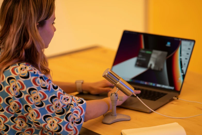 a woman is sitting at a desk using a laptop