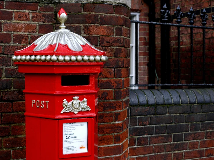 a red post box painted red with a crown on top