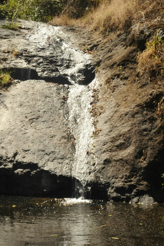 waterfall near a rocky bank in an arid area