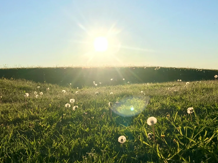 a sun shines through the clouds over the field