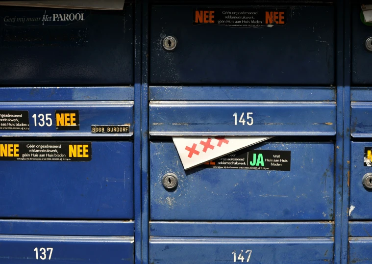 several blue mail boxes with different stickers on them