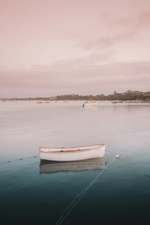 a small white boat sitting in the ocean