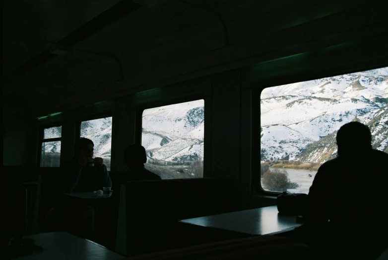 people are sitting in train car watching mountains through windows