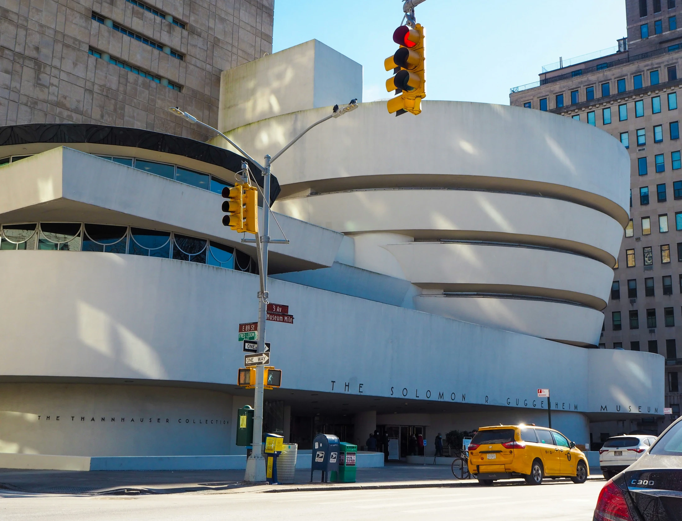 a taxi cab waiting at the corner of an intersection