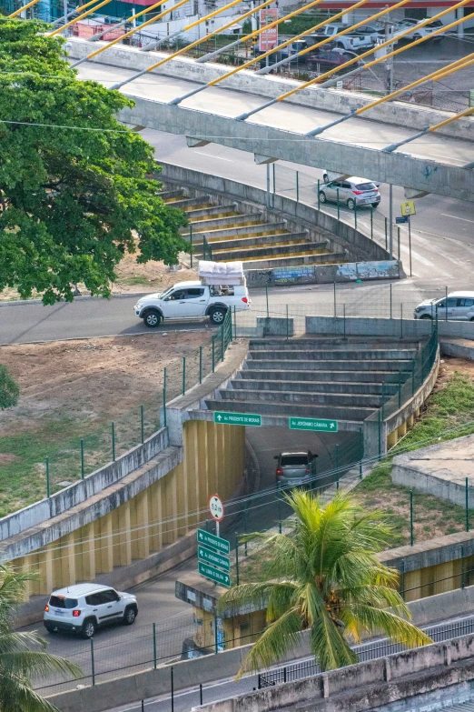 cars driving down the highway and stairs in front of an abandoned building