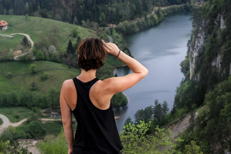 a man overlooking a river and mountains with a scenic backdrop