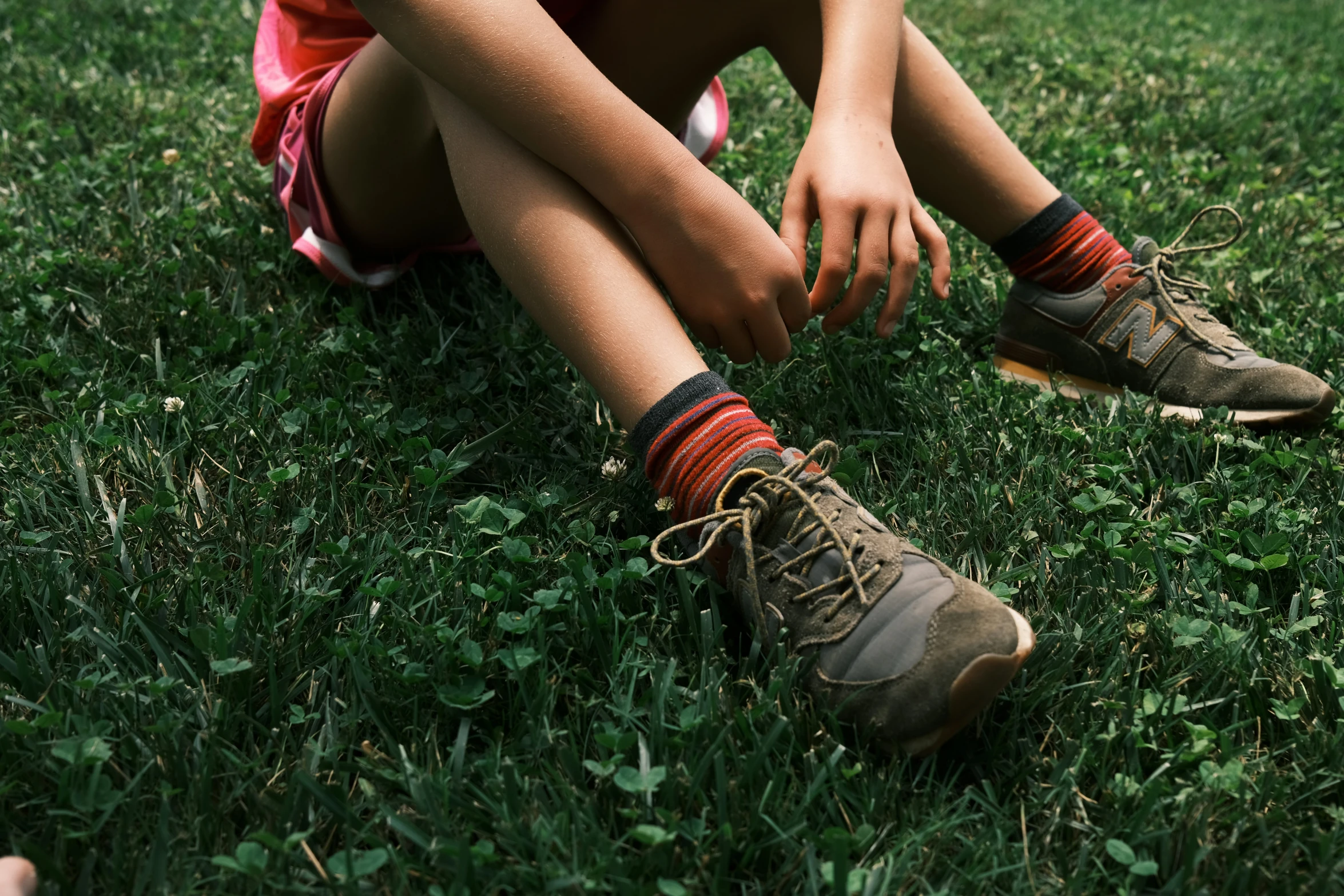 the girl is sitting down in the grass