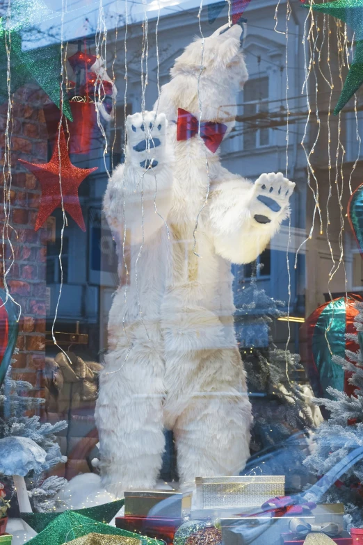 a white teddy bear dressed in sunglasses and holding a red bow