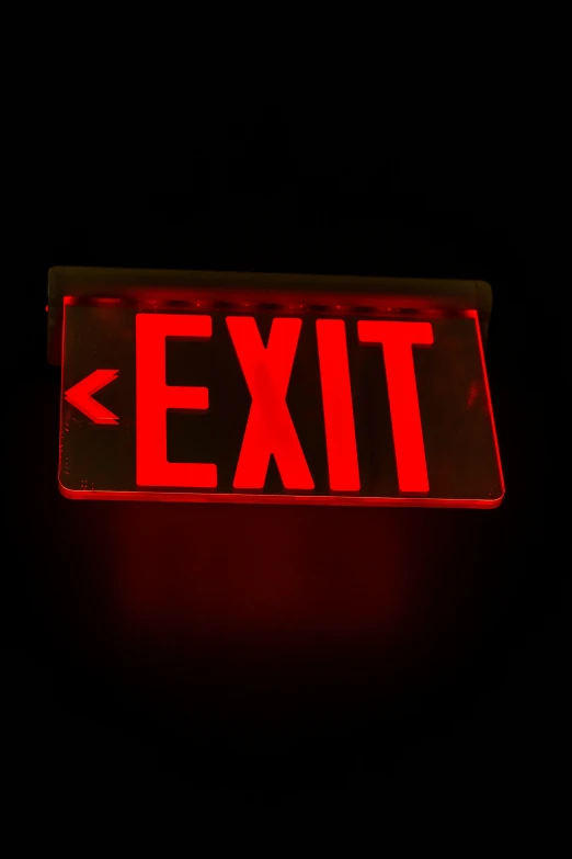 a red exit sign on a black background