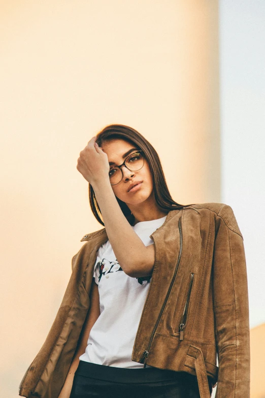 a woman in black pants and a tan jacket