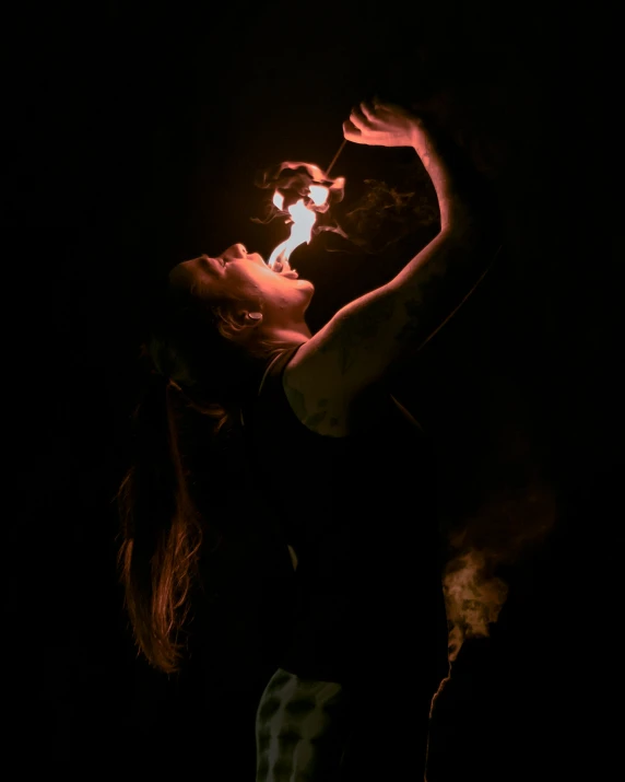 a girl holding a small lit match in her hand