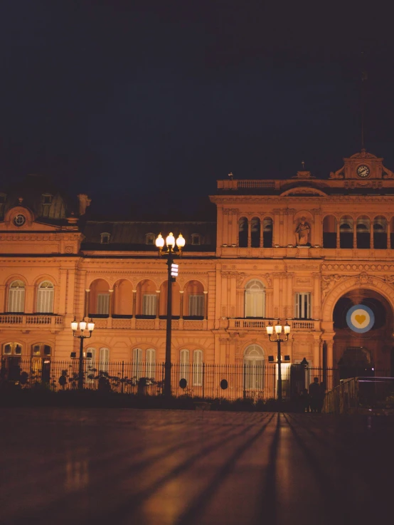 the large building has many windows, all at night