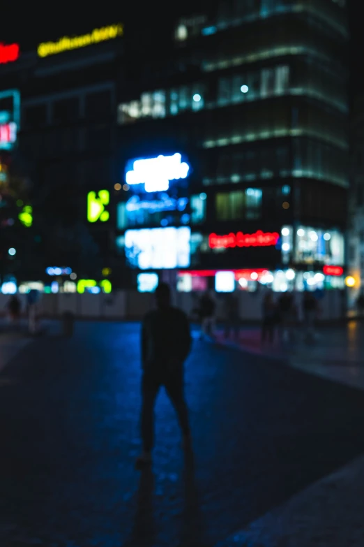 a man is standing alone in a city at night