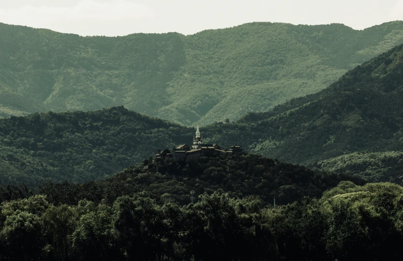 green landscape with mountains and trees and hills on the far left side