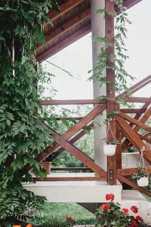 plants and flowers on a balcony next to a wooden structure