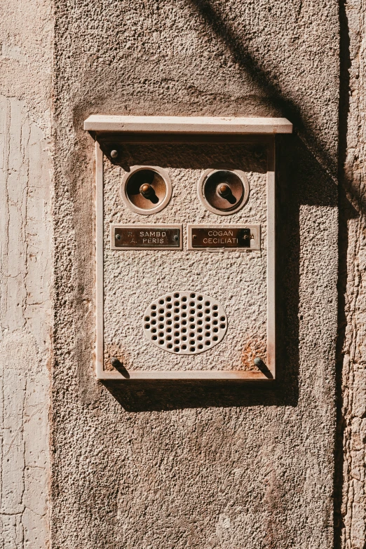 an old grey radio placed in front of a cement wall