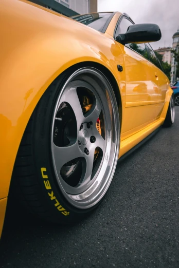 the rims of a yellow sports car parked on the street