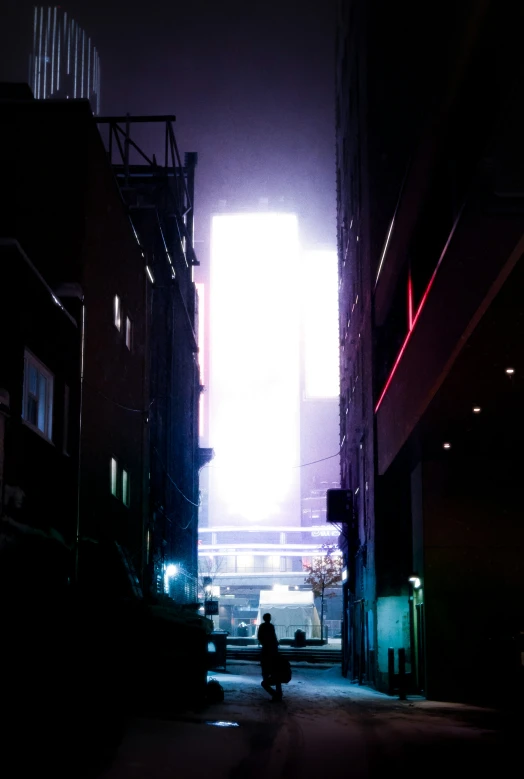 a person sitting on the curb in a dark alley