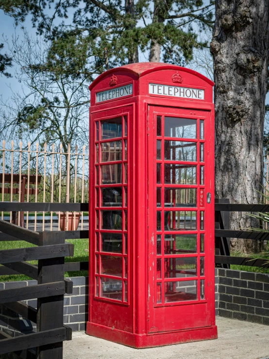 a red phone booth on the side of a street