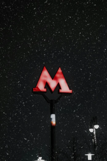 red neon sign showing the letter m at night
