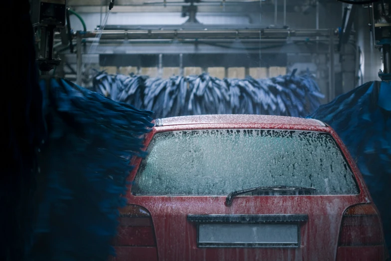 a red car parked under an open air furnace