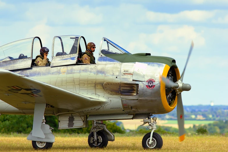 two pilots sitting in the cockpit of an old war bomber