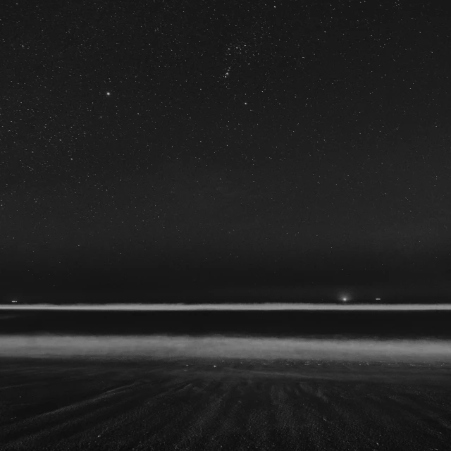 an empty field at night with the stars above