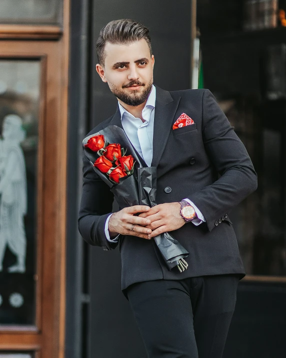 a man in a black suit with flowers