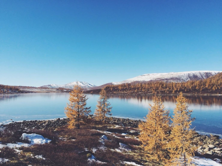 a lake in the middle of nowhere is covered with snow