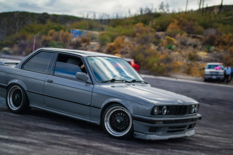 a gray car parked on the side of a dirt road