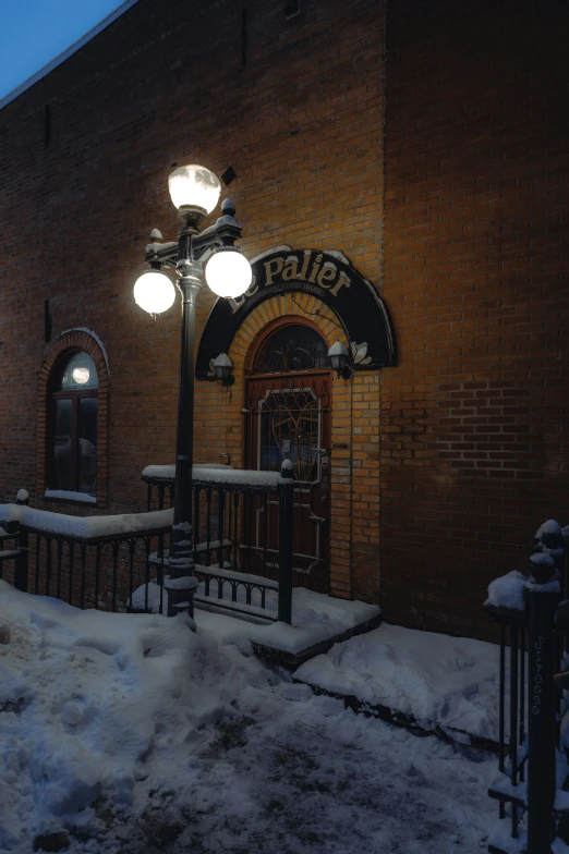 a street light sitting in the snow next to a building