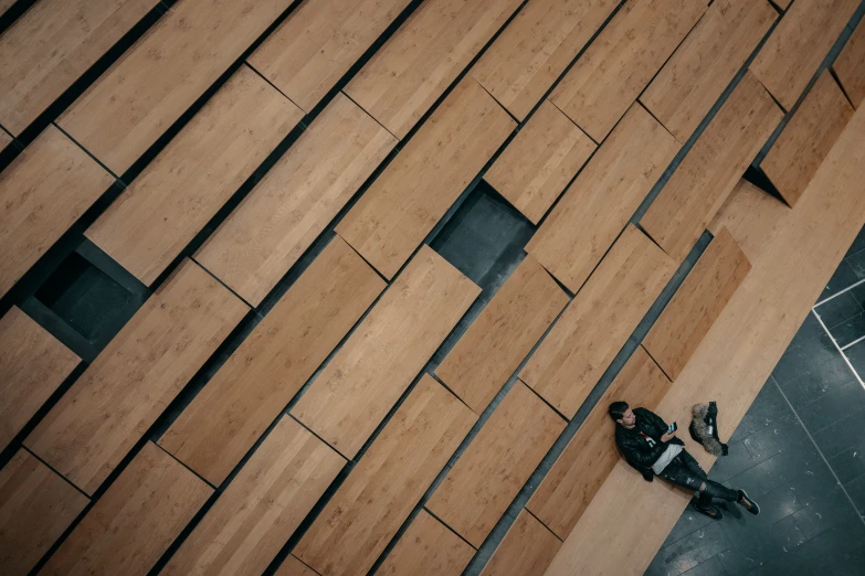 there is a man sitting on the pavement next to a building