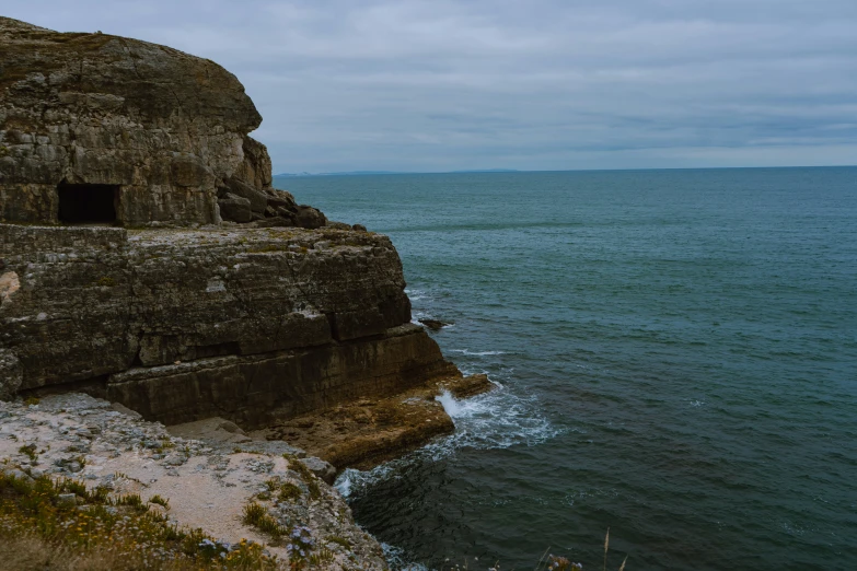 an image of a cliff with water and ocean in the background