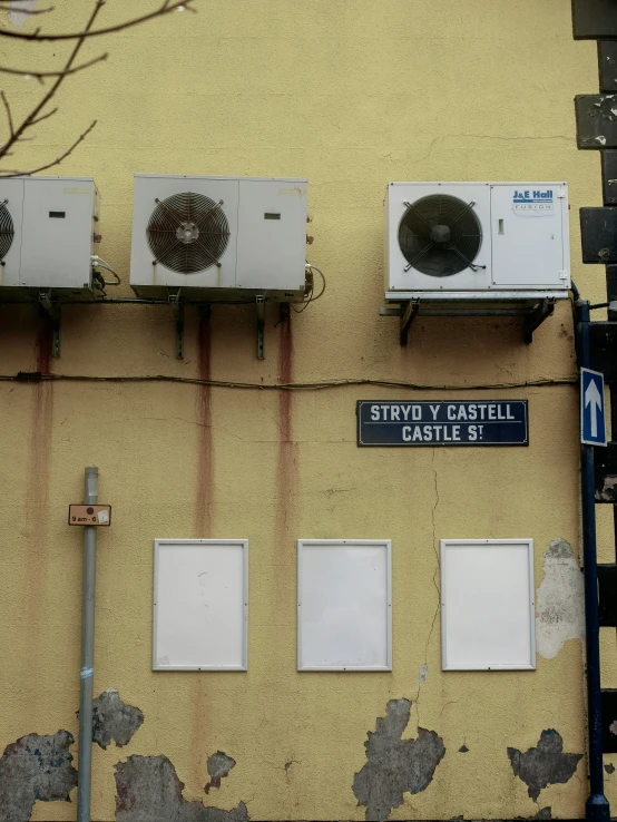 there are three air conditioning units that are hanging on the side of the building