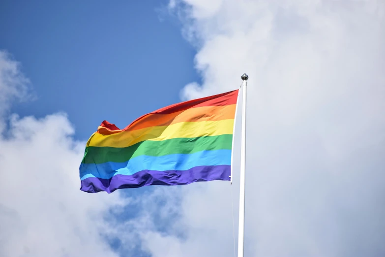 a flag flies in the air with a blue sky behind